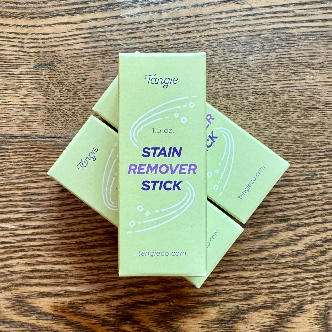 A rectangular yellowish box that says &quot;Stain Remover Stick&quot; in blue block letters, with the company name &quot;Tangie&quot; at the top, and the company website &quot;tangieco.com&quot; at the bottom. 
